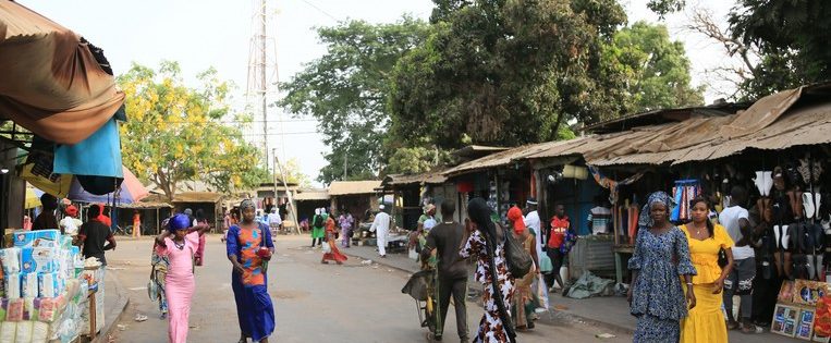De grote markt in de West-Gambiaanse stad Brikama, waar je terecht kunt voor fruit, flatscreens, stoffen en smartphones , is ’s avonds een gezellige chaos.